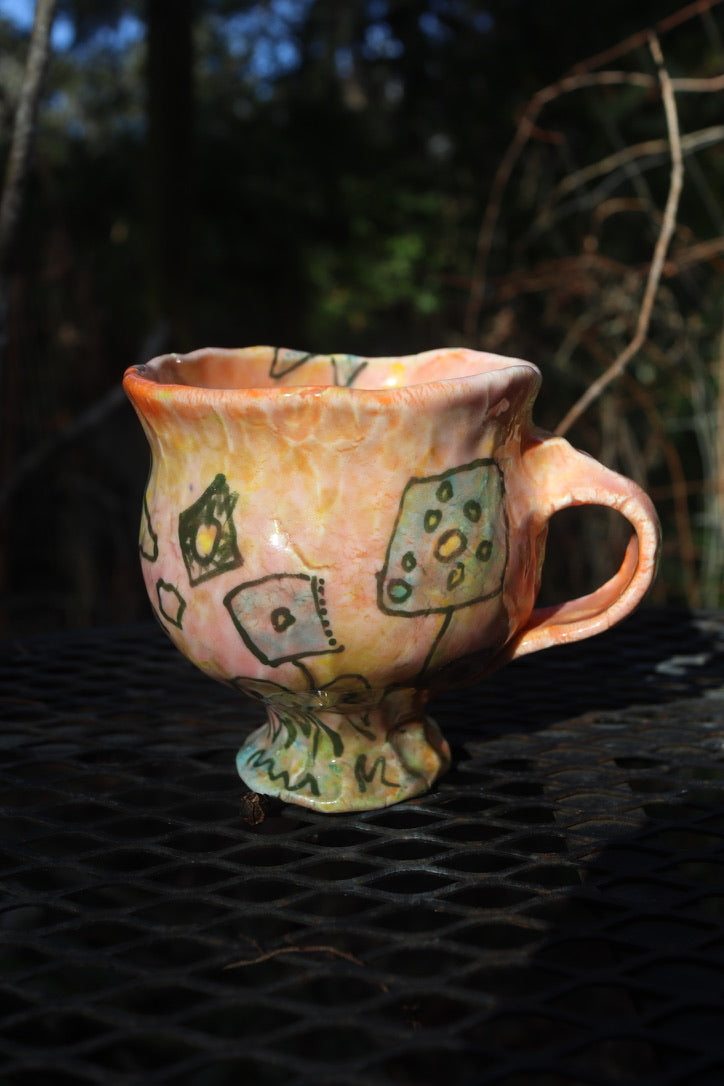 Handmade ceramic mug with abstract designs on a dark surface