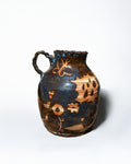 Ceramic pitcher with decorative patterns on a white background